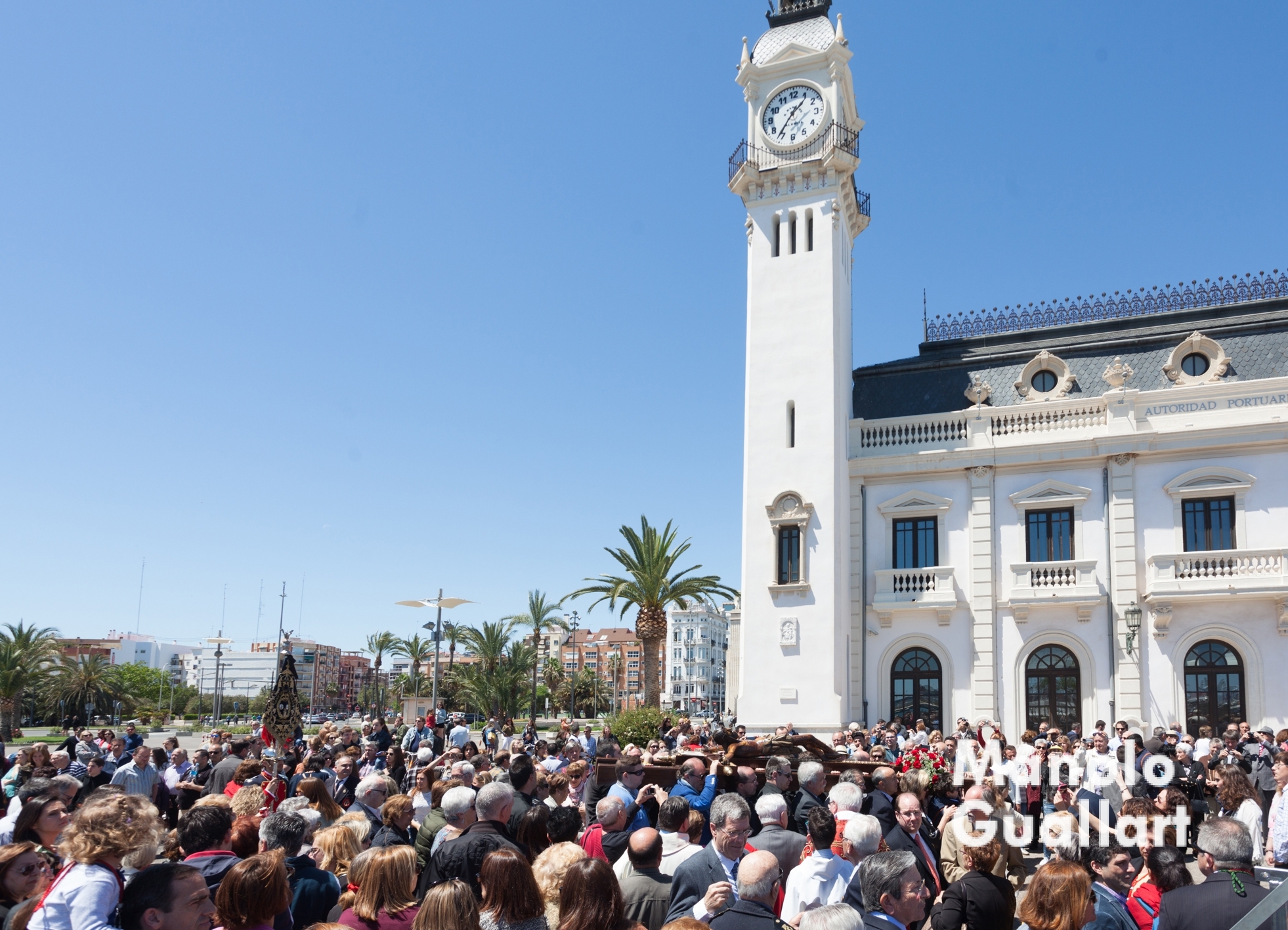 El Cristo del Grao pasa ante el Edificio del Reloj en el puerto de Valencia. Foto de Manolo Guallart.