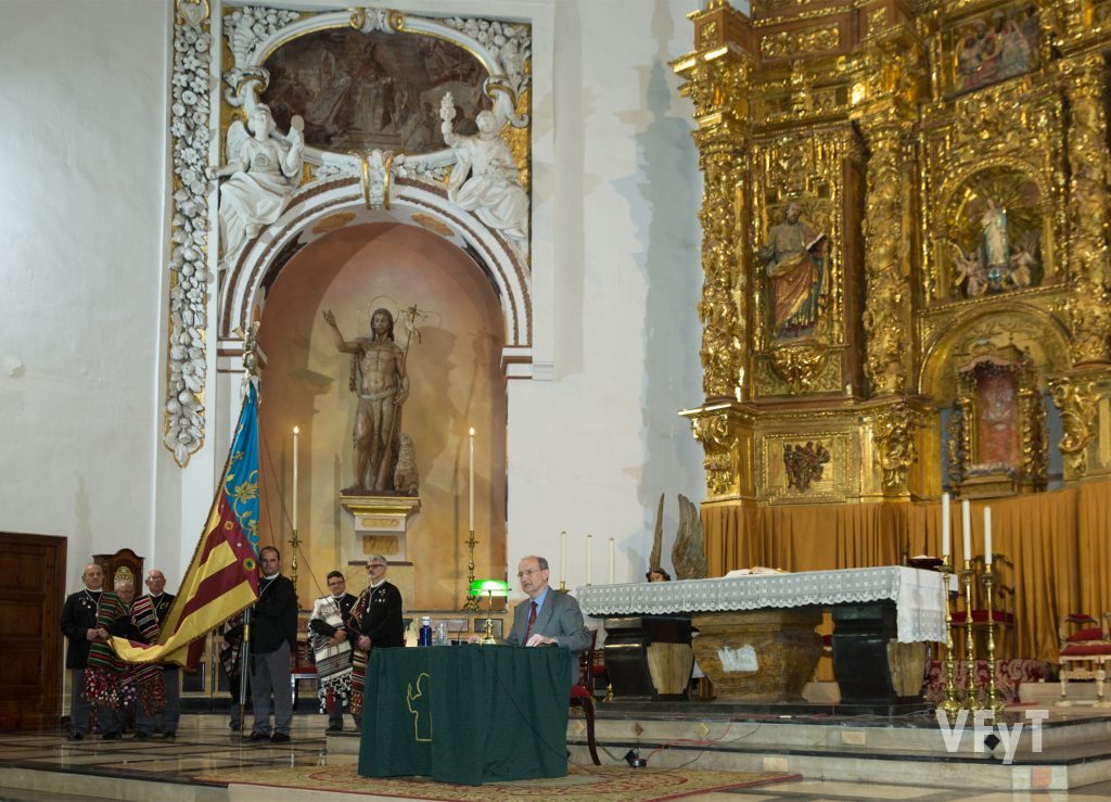 El Pregón de las Fiestas Vicentinas, organizado por el Alatr del Mercat. Francisco Borrás, en el altar mayor de la parroquia de los Santos Juanes anuncia las celebraciones ante la Real Senyera del altar.