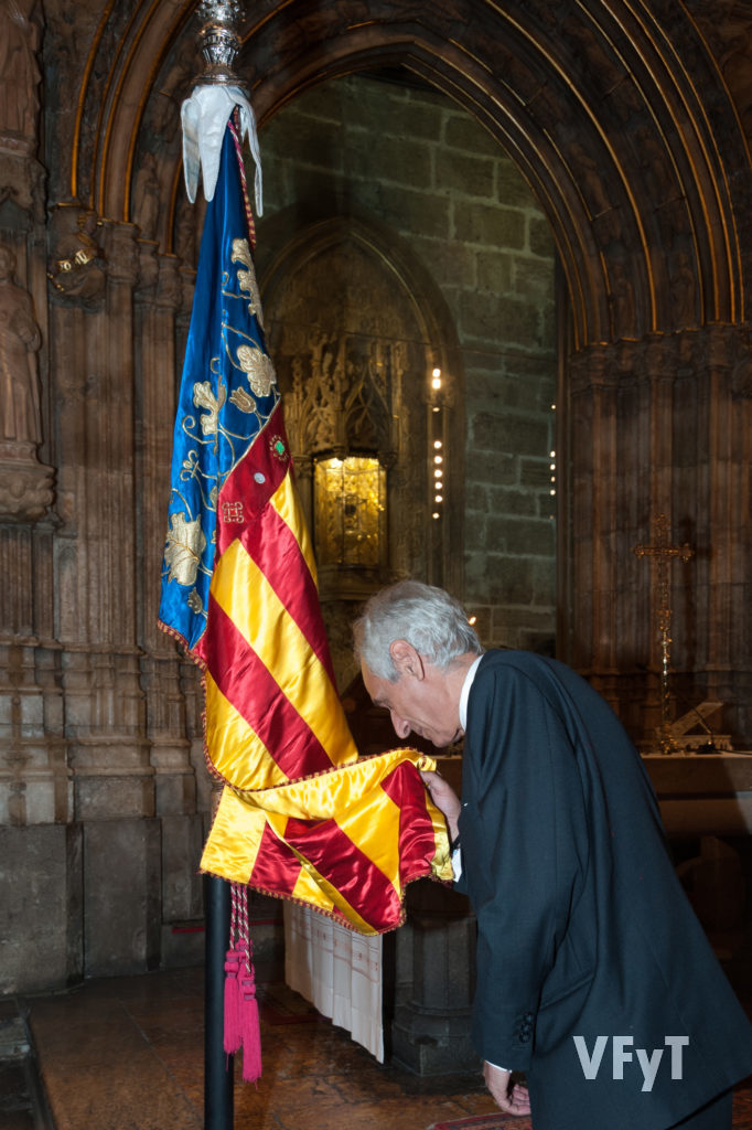 Miquel Ramón, Lloctinent General del Centenar de la Ploma, besa la Real Senyera ante el Santo Cáliz.